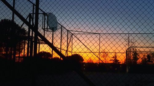 Scenic view of silhouette fence against sky during sunset