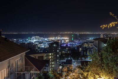 High angle view of illuminated buildings against sky at night