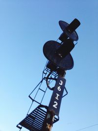 Low angle view of sign against clear blue sky