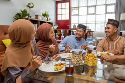 Smiling friends having food at home