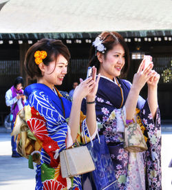 Portrait of happy friends holding camera