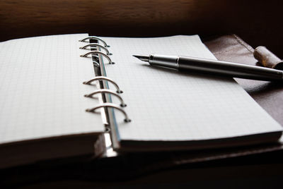 Close-up of pen and book on table