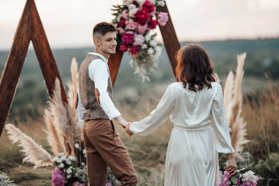 Rear view of couple standing on land