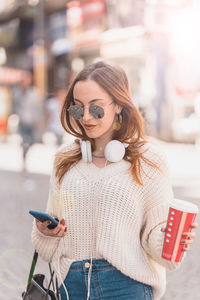 Portrait of woman holding smart phone outdoors