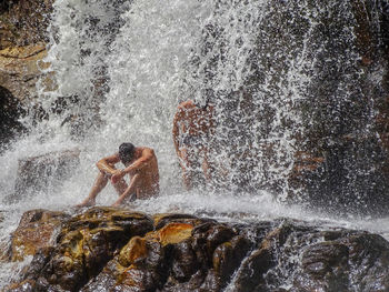 People enjoying under waterfall 
