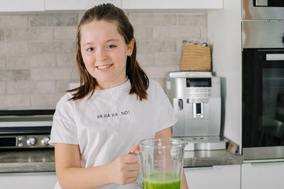 Portrait of smiling young woman sitting at home