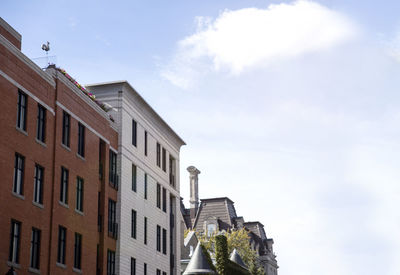 Low angle view of buildings against cloudy sky