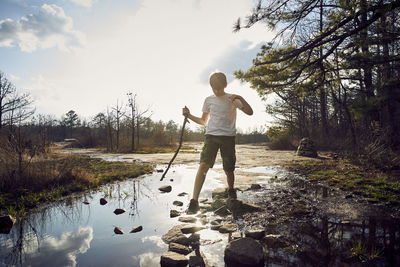 Boy hiking on arabia mountain against cloudy sky