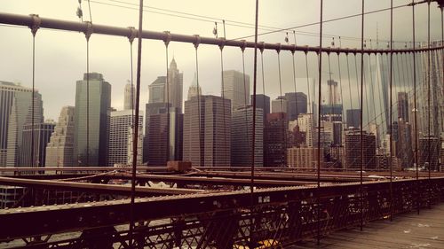 View of suspension bridge in city against sky