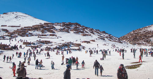 People on snowcapped mountain against sky