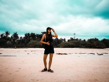 Full length of woman standing on road against sky