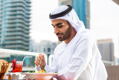 Young man holding ice cream on table