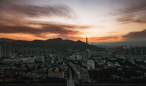 High angle view of buildings in city against sky during sunset