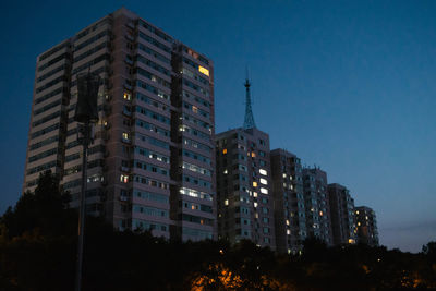 Low angle view of illuminated buildings against sky at night