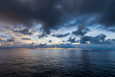 Scenic view of sea against dramatic sky during sunset