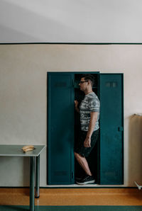 Full length of young man looking at camera on table