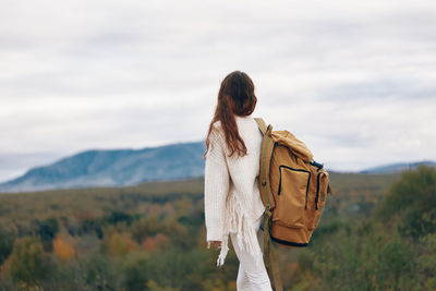 Rear view of woman standing against mountain