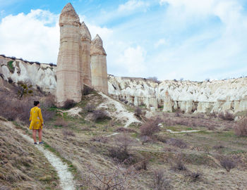 Rear view of a man walking on stone wall