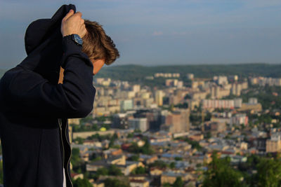 Side view of man looking at cityscape