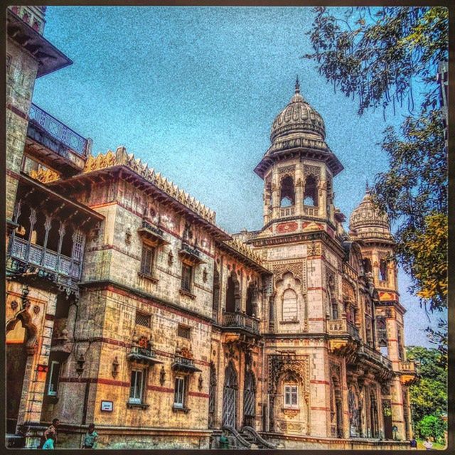 building exterior, architecture, built structure, transfer print, auto post production filter, low angle view, sky, church, religion, city, place of worship, spirituality, facade, blue, outdoors, cloud - sky, cathedral, tree