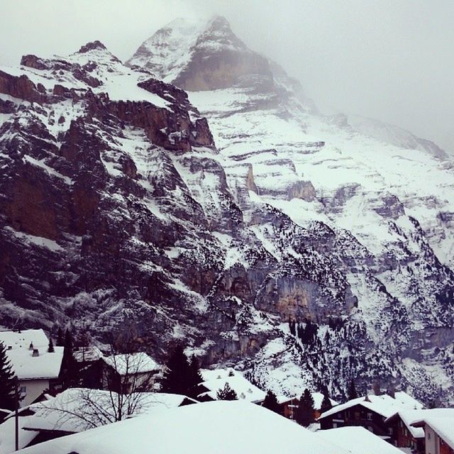 snow, winter, mountain, cold temperature, season, building exterior, mountain range, snowcapped mountain, weather, architecture, built structure, covering, high angle view, clear sky, scenics, nature, white color, landscape, beauty in nature, tranquility