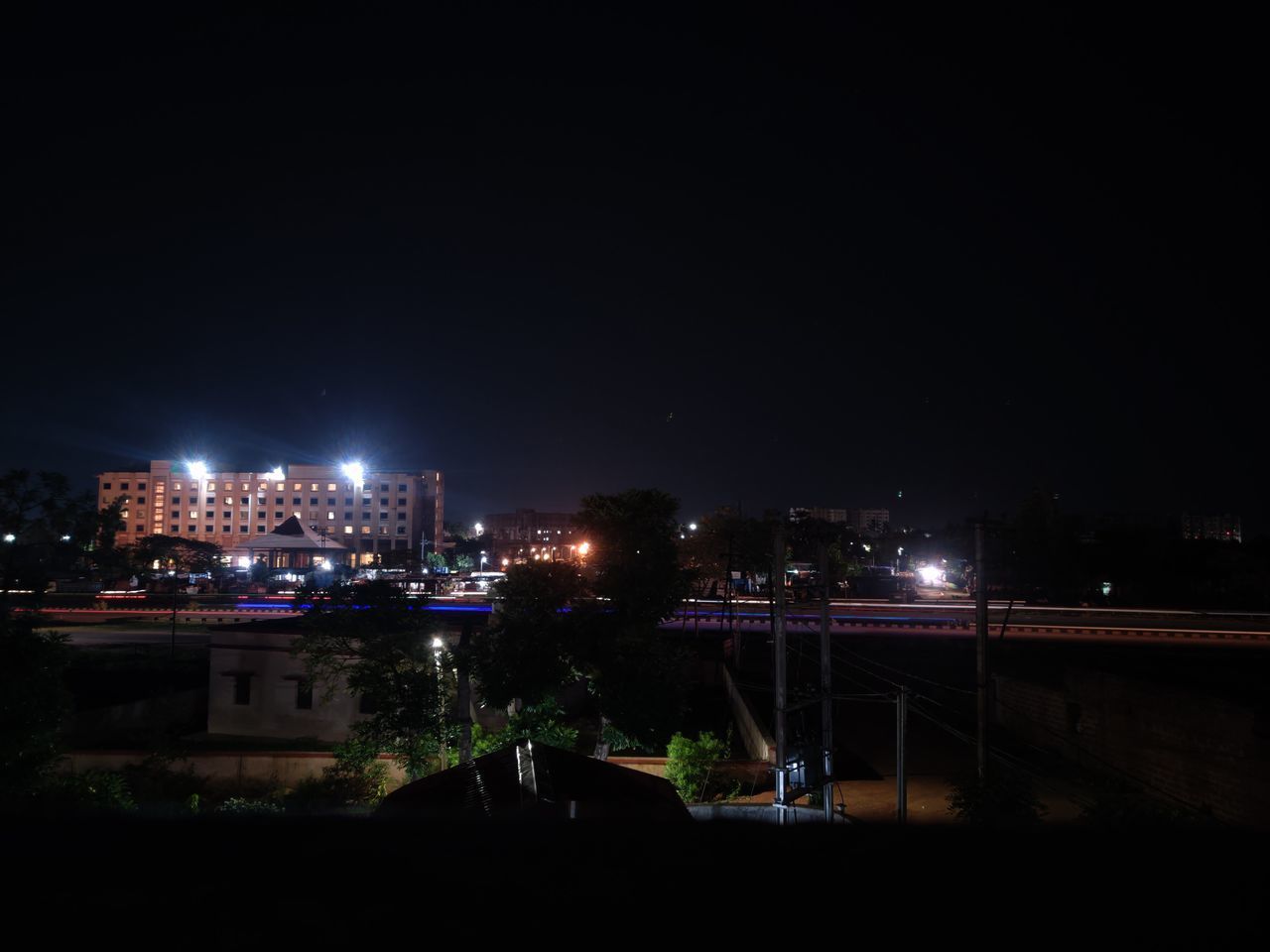 HIGH ANGLE VIEW OF ILLUMINATED CITY BUILDINGS AGAINST CLEAR SKY