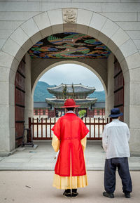 Rear view of people in traditional clothing standing at gwanghwamun