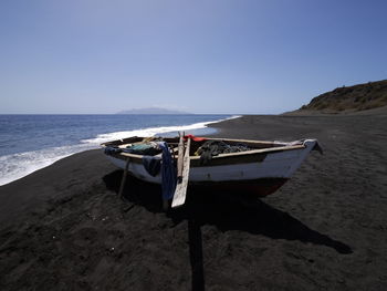 Scenic view of beach against clear sky with rowboat -fisherboat- in the foreground