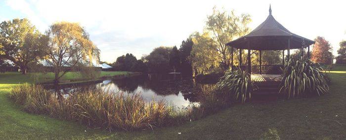 Gazebo by lake against sky