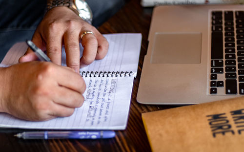 Midsection of man using smart phone on table