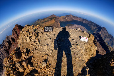 Fish-eye view of shadow on mountain against sky