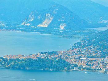 Aerial view of city by sea against sky