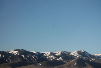 Low angle view of mountains against clear blue sky