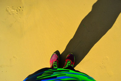 Low section of person standing on yellow floor