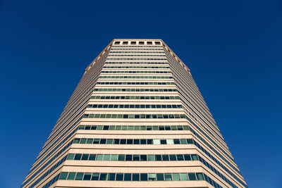 Low angle view of modern building against clear blue sky