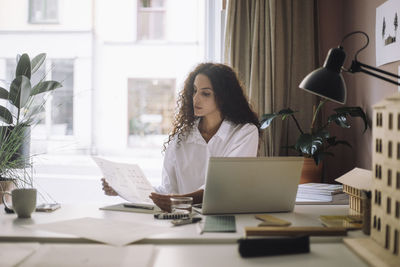 Young businesswoman using laptop at table