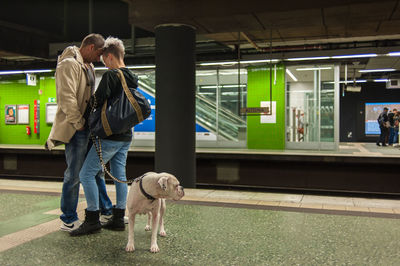 Rear view of man and woman standing with dog