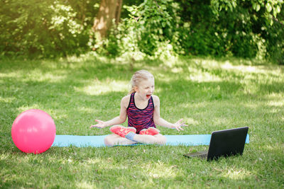 Angry mad girl child doing sport workout outdoors online. video yoga class on internet. 