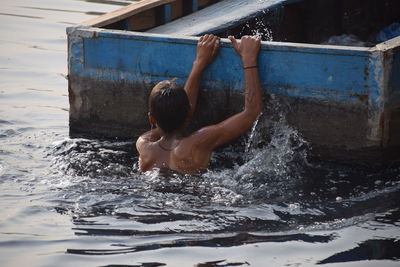 Rear view of shirtless boy in swimming