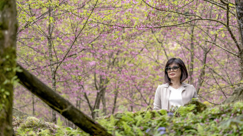 Portrait of woman with pink cherry blossoms in spring