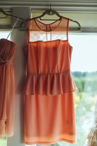 Dress hanging on window at home