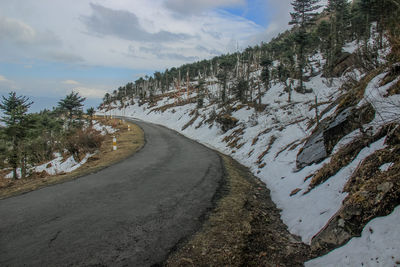 Road amidst trees against sky