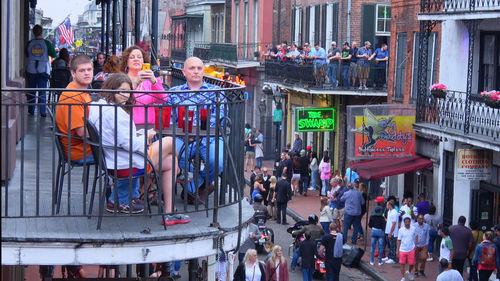 People on street against buildings in city