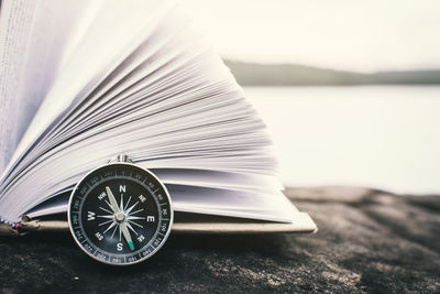 Close-up of open book on table by lake