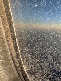 Scenic view of sky seen through wet glass window