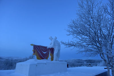 Statue against clear blue sky during winter