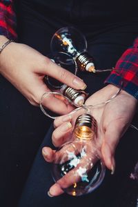 Midsection of man holding light bulb