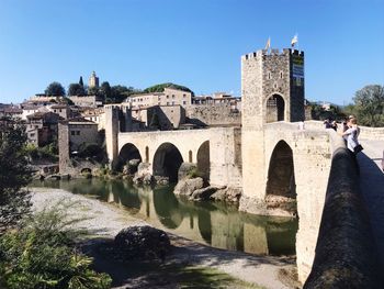 Arch bridge over river against sky