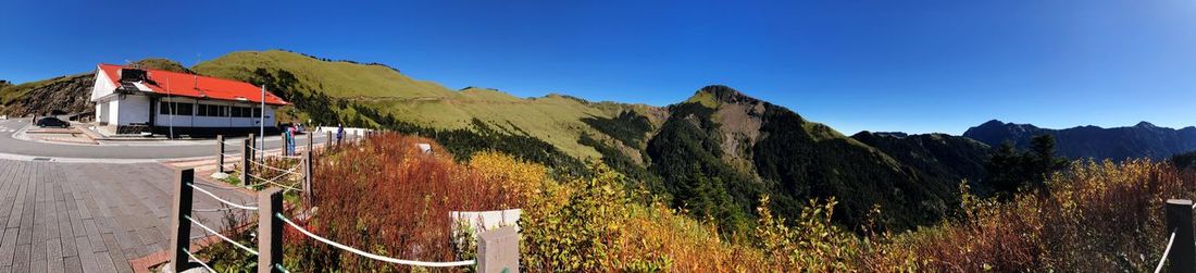 Panoramic view of houses against clear blue sky