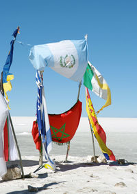 Umbrellas on beach against clear blue sky